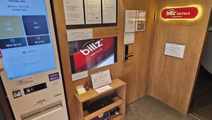 A hotel reception area with a digital kiosk, a TV screen displaying the hotel name, and various informational signs. - Billz Hotel Dongdaemoon  (Seoul)