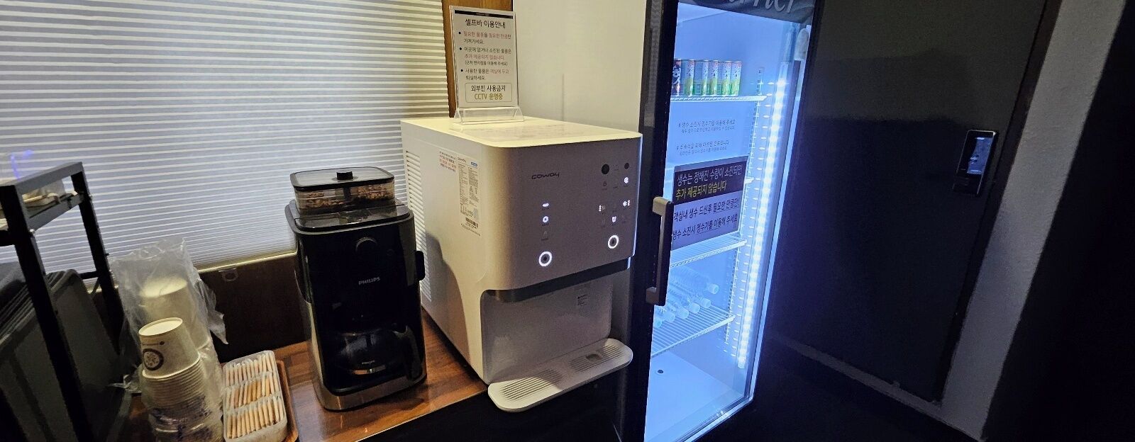 Une machine à café, un réfrigérateur et un autre appareil à café sont posés sur un comptoir.