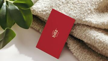 A red card with the text "billz hotels" placed on a textured beige surface, possibly a towel or fabric.