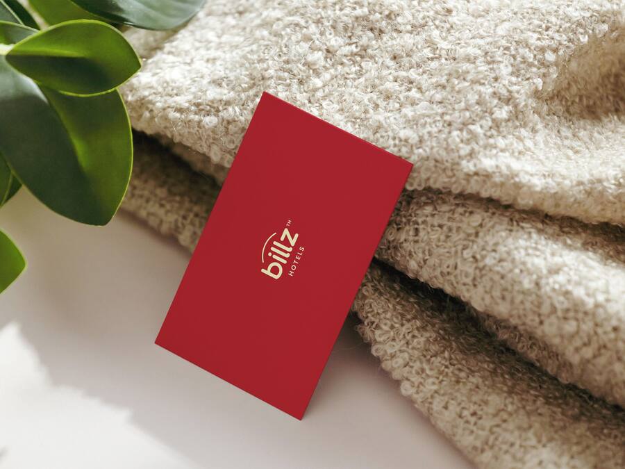 A red card with the text "billz hotels" placed on a textured beige surface, possibly a towel or fabric.