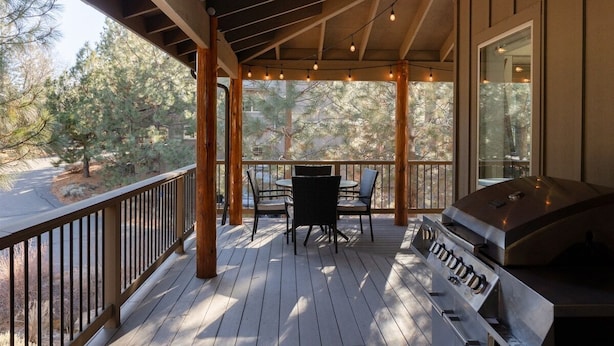 A covered outdoor deck with a grill, dining table, and chairs. - Bluebird Day - Big River, Luxurious 4BR home in Bend, perfect for families or groups of up to 8. (Bend)