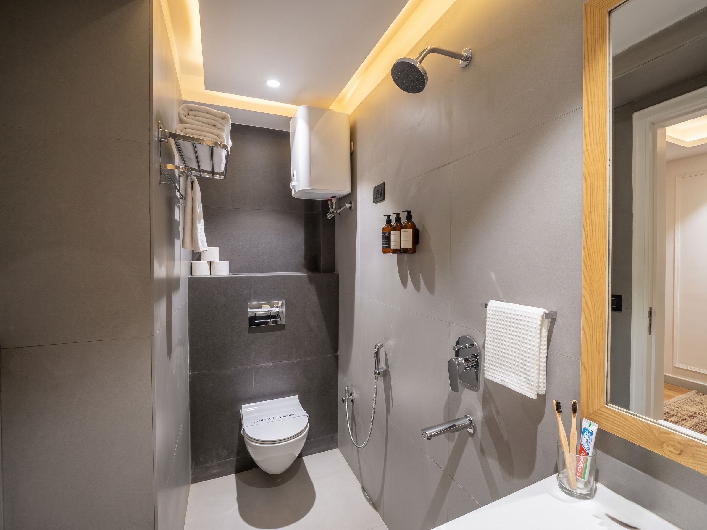A modern bathroom with a toilet, shower, and sink.