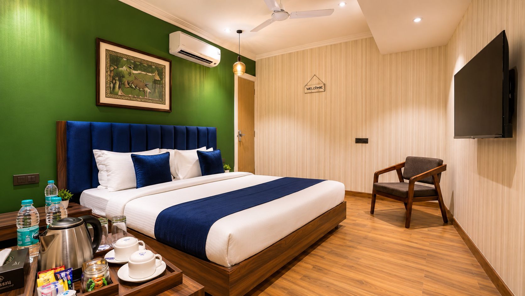 Quarto de hotel com cama, uma cadeira, televisão e um sinal de boas-vindas.