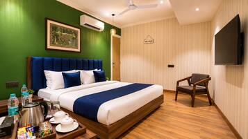 Quarto de hotel com cama, uma cadeira, televisão e um sinal de boas-vindas.