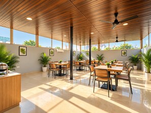 Amplio espacio interior con techo de madera, varias mesas y sillas, plantas en macetas y grandes ventanales que ofrecen vistas panorámicas de la ciudad.