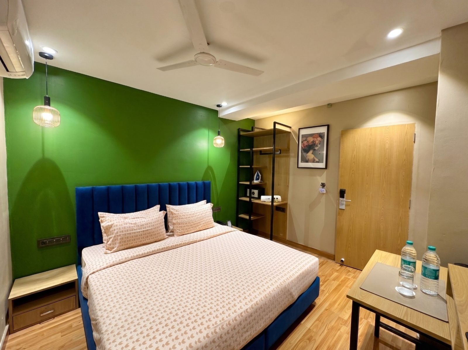 A hotel room with a bed, a desk, a chair, a wardrobe, and a bathroom.