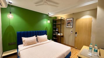 A hotel room with a bed, a desk, a chair, a wardrobe, and a bathroom.