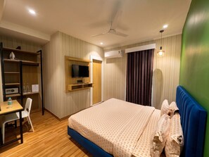 A hotel room with a bed, a desk, a television, and a wardrobe. - asar Connaught Place by Orion Hotels (New Delhi)
