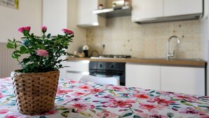 A kitchen with white cabinets, a stainless steel sink, and a tiled backsplash.