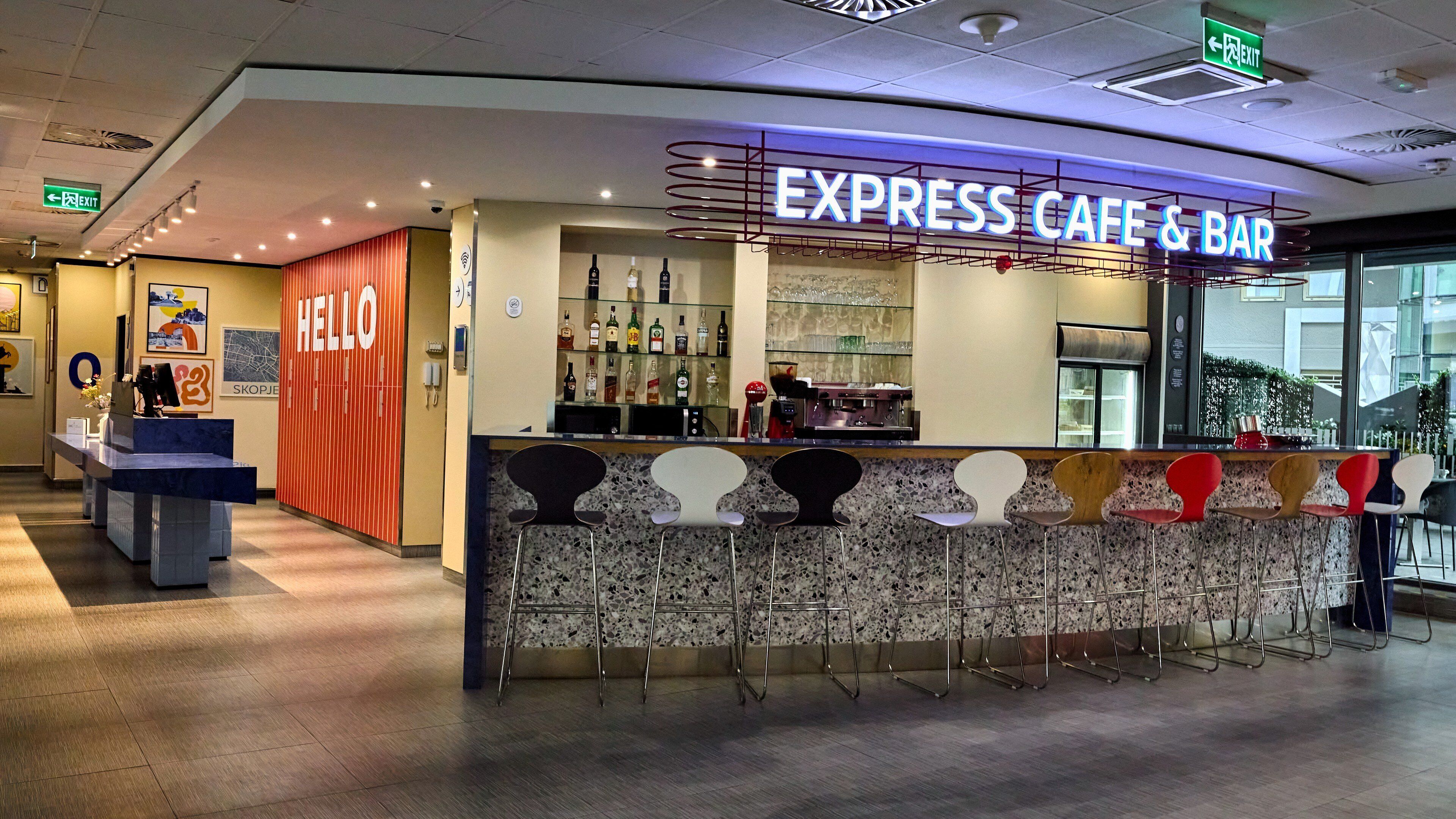 A cafe bar with a counter, bar stools, and a 'HELLO' sign.