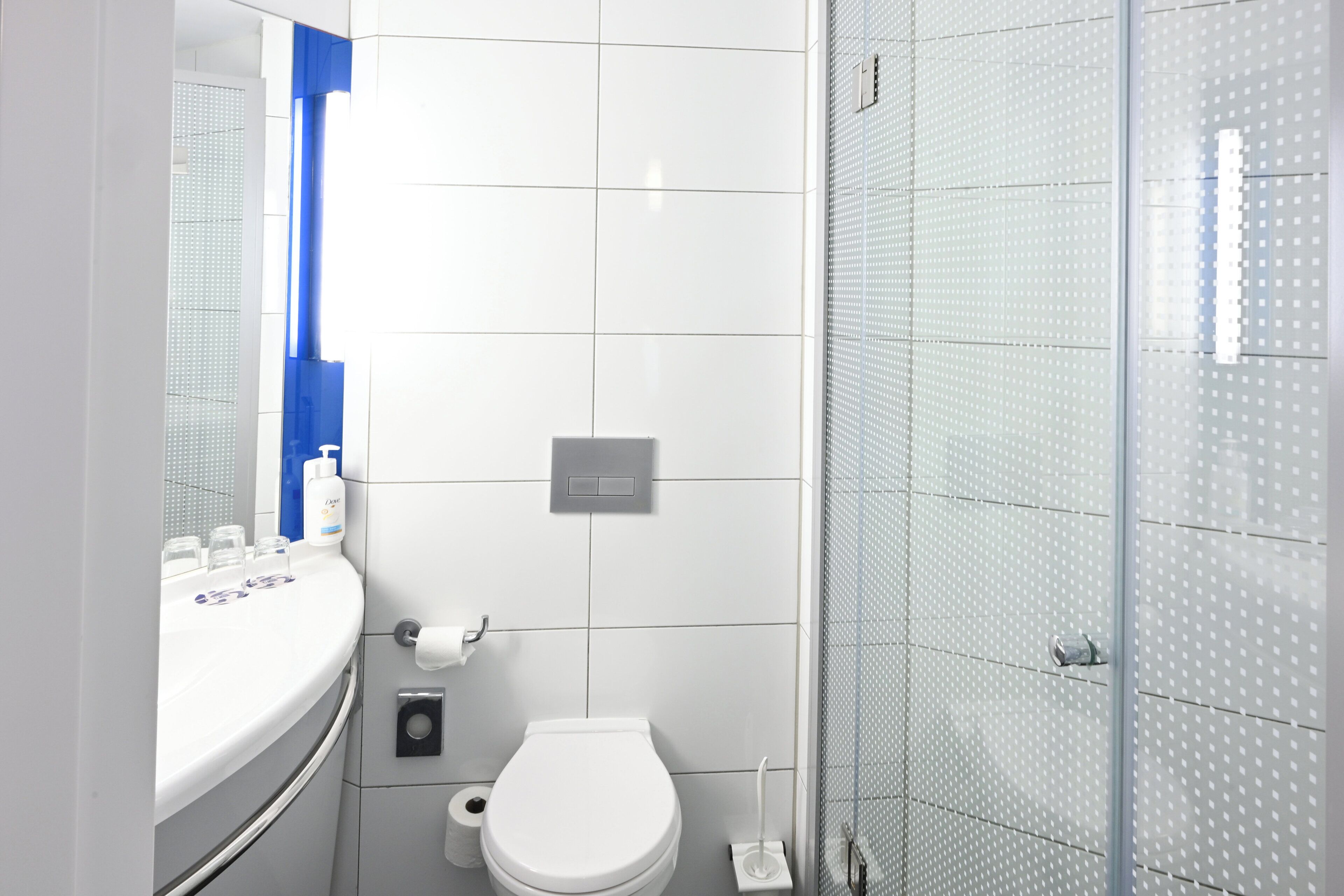 A modern bathroom with a toilet, sink, and shower.