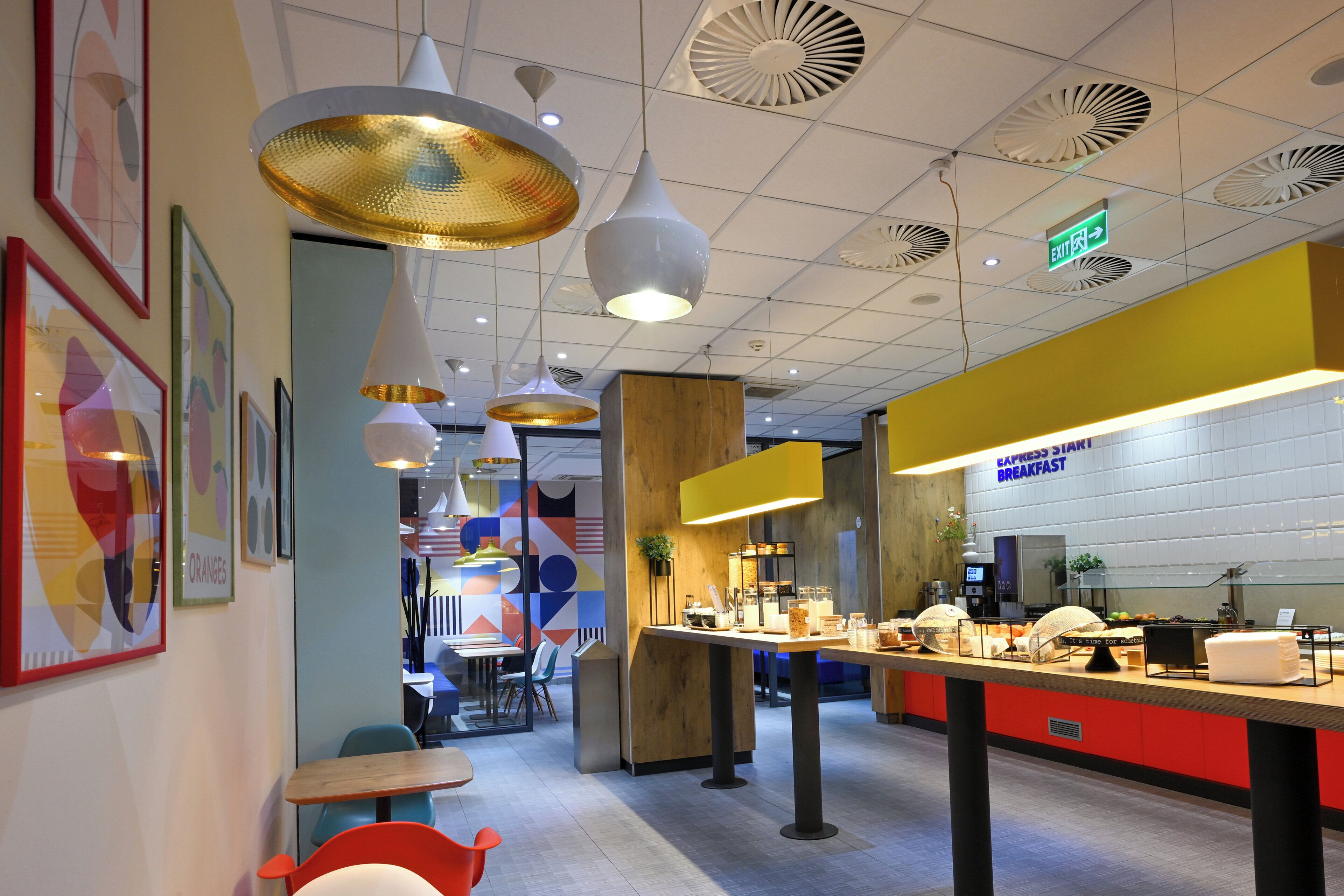A breakfast area with a counter, seating, and hanging pendant lights.