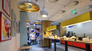 A breakfast area with a counter, seating, and hanging pendant lights.