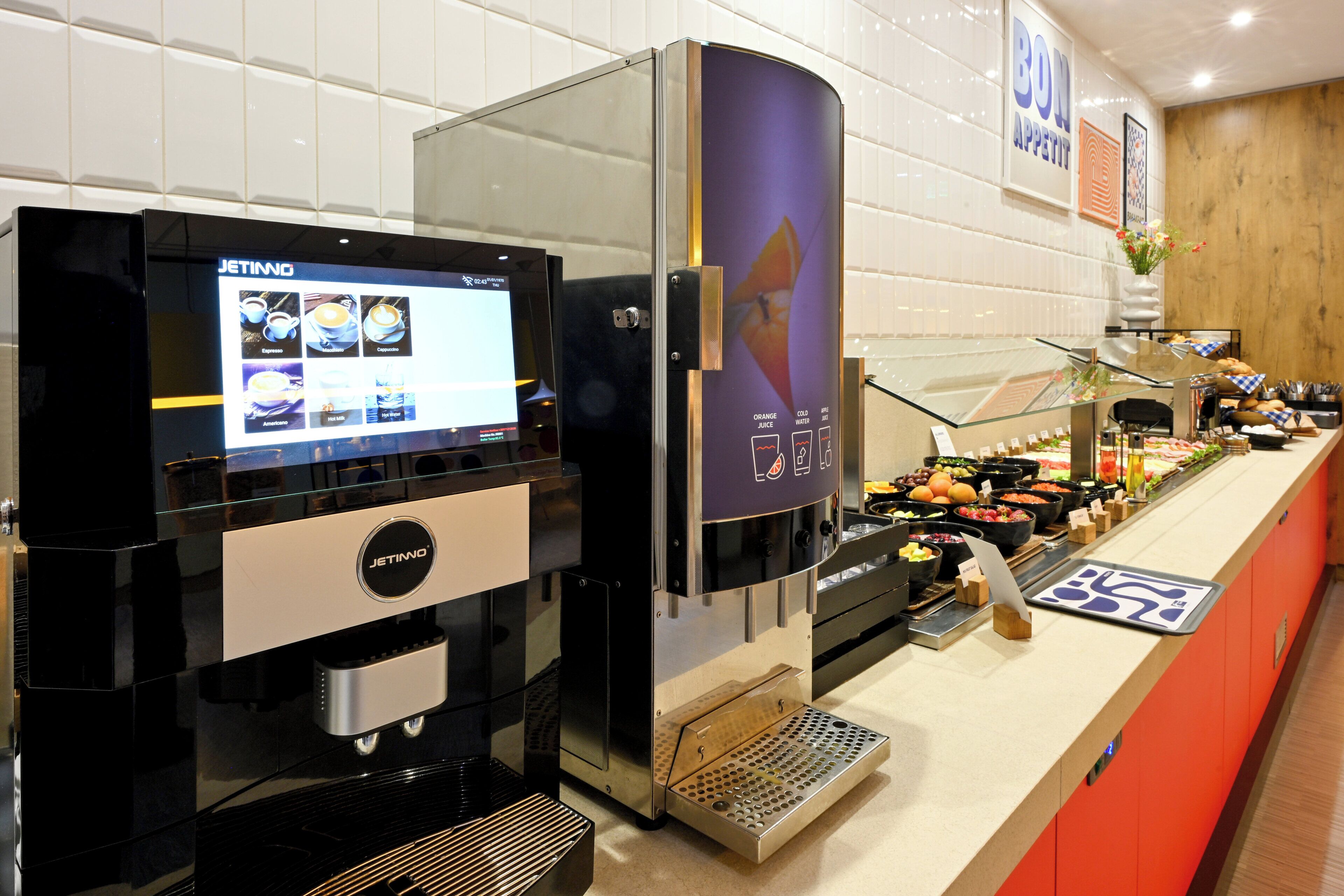 A coffee machine with a digital display, a beverage dispenser, and a counter with various food items.