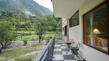 A balcony with a checkered floor, two chairs, and a table.