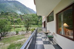 A balcony with a checkered floor, two chairs, and a table. - Mashru Riverside Estate (Banjar)