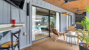 A modern outdoor patio with a pool, wooden furniture, and ceiling fans. - 2 Blocks to Golf Course: Spacious Tampa Home! (Tampa)