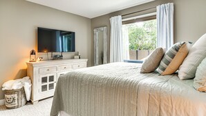A bedroom with a bed, a TV, a ceiling fan, a dresser, and a window with curtains. - 2 Blocks to Golf Course: Spacious Tampa Home! (Tampa)