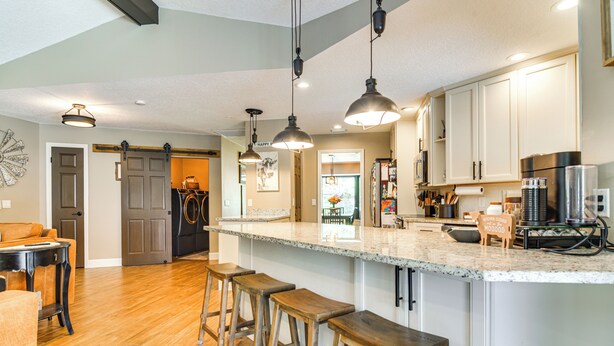 A spacious kitchen with a large island, bar stools, pendant lighting, and modern appliances. - 2 Blocks to Golf Course: Spacious Tampa Home! (Tampa)