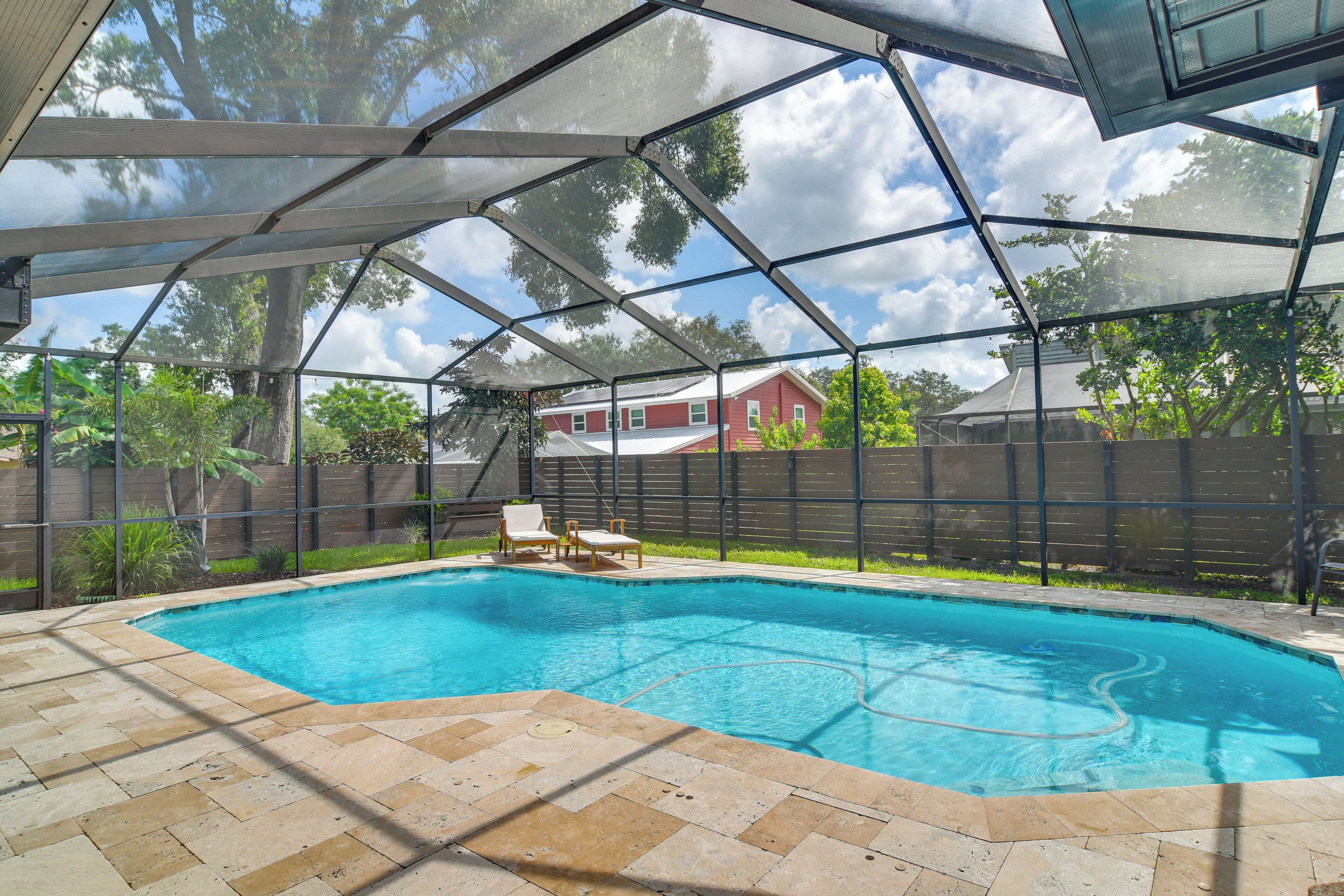Ein überdachter Pool im Freien mit Blick auf ein Haus im Hintergrund.