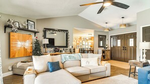 A spacious living room with a large sectional sofa, a ceiling fan, and a fireplace. - 2 Blocks to Golf Course: Spacious Tampa Home! (Tampa)