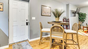 A room with a white door, a round table with chairs, a potted plant, and a framed picture on the wall. - 4 Mi to Dtwn Indianapolis: Quiet Apartment w/ Yard (Indianapolis)