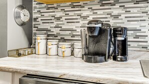A kitchen with a coffee maker, a clock, and jars on the counter. - 4 Mi to Dtwn Indianapolis: Quiet Apartment w/ Yard (Indianapolis)