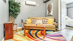 A living room with a sofa, coffee table, and a colorful rug. - 4 Mi to Dtwn Indianapolis: Quiet Apartment w/ Yard (Indianapolis)