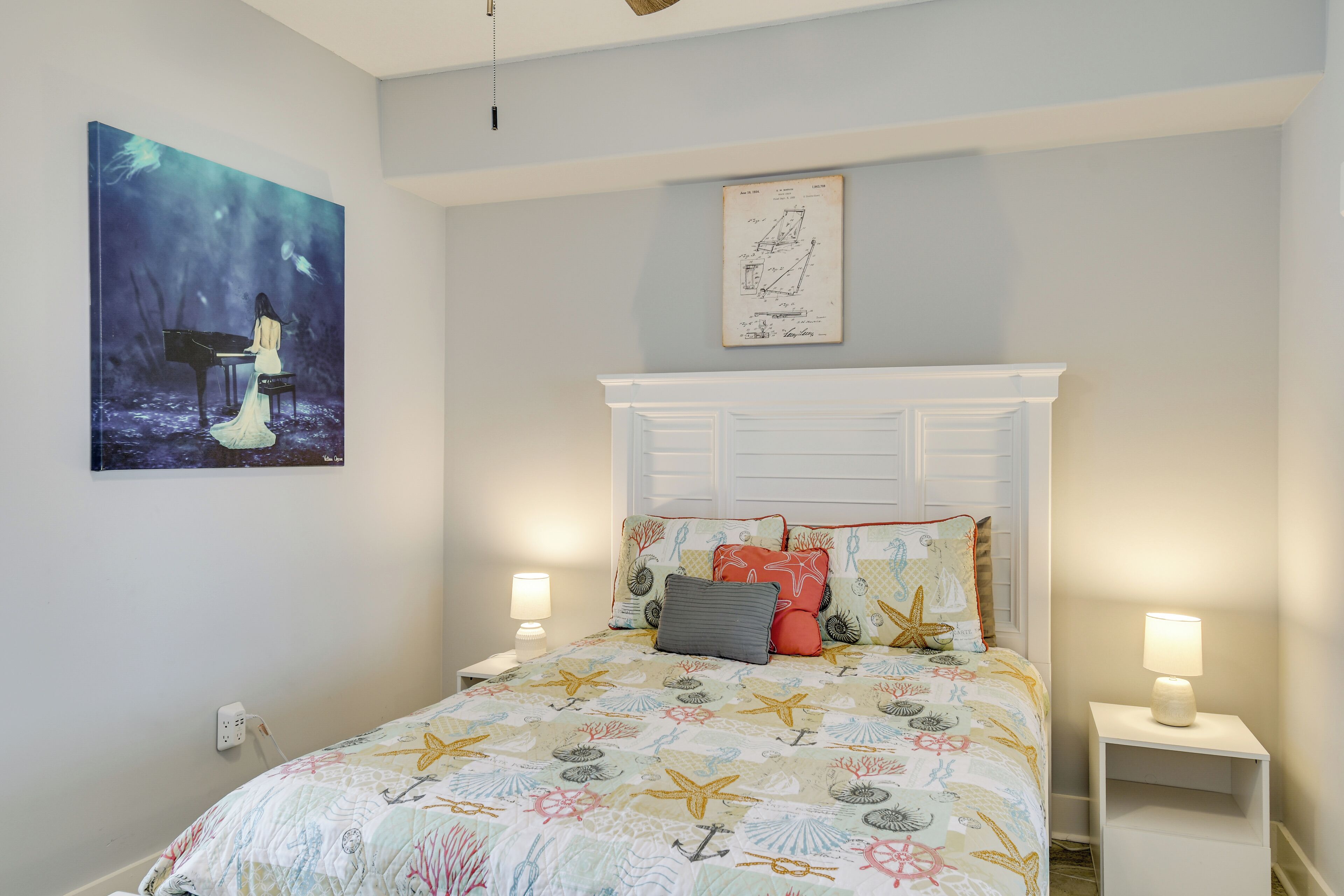 Une chambre à coucher avec un lit, des tables de chevet, un tableau et un plan architectural encadré accroché au mur.
