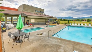 A swimming pool area with a covered patio, outdoor seating, and a view of mountains. - Mountain Views & Year-round Fun: Fraser Getaway! (Fraser)