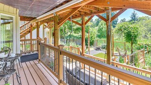 A wooden deck with a railing, a table with chairs, and a hammock. - Backs to Wetlands: Tranquil Beaverton Retreat! (Beaverton)