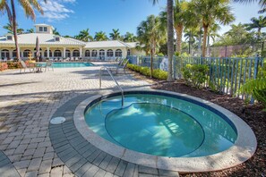 A swimming pool with a brick deck, surrounded by palm trees and a fenced area. - 3 Mi to Dtwn Fort Myers: Condo w/ Pool & Hot Tub (North Fort Myers)