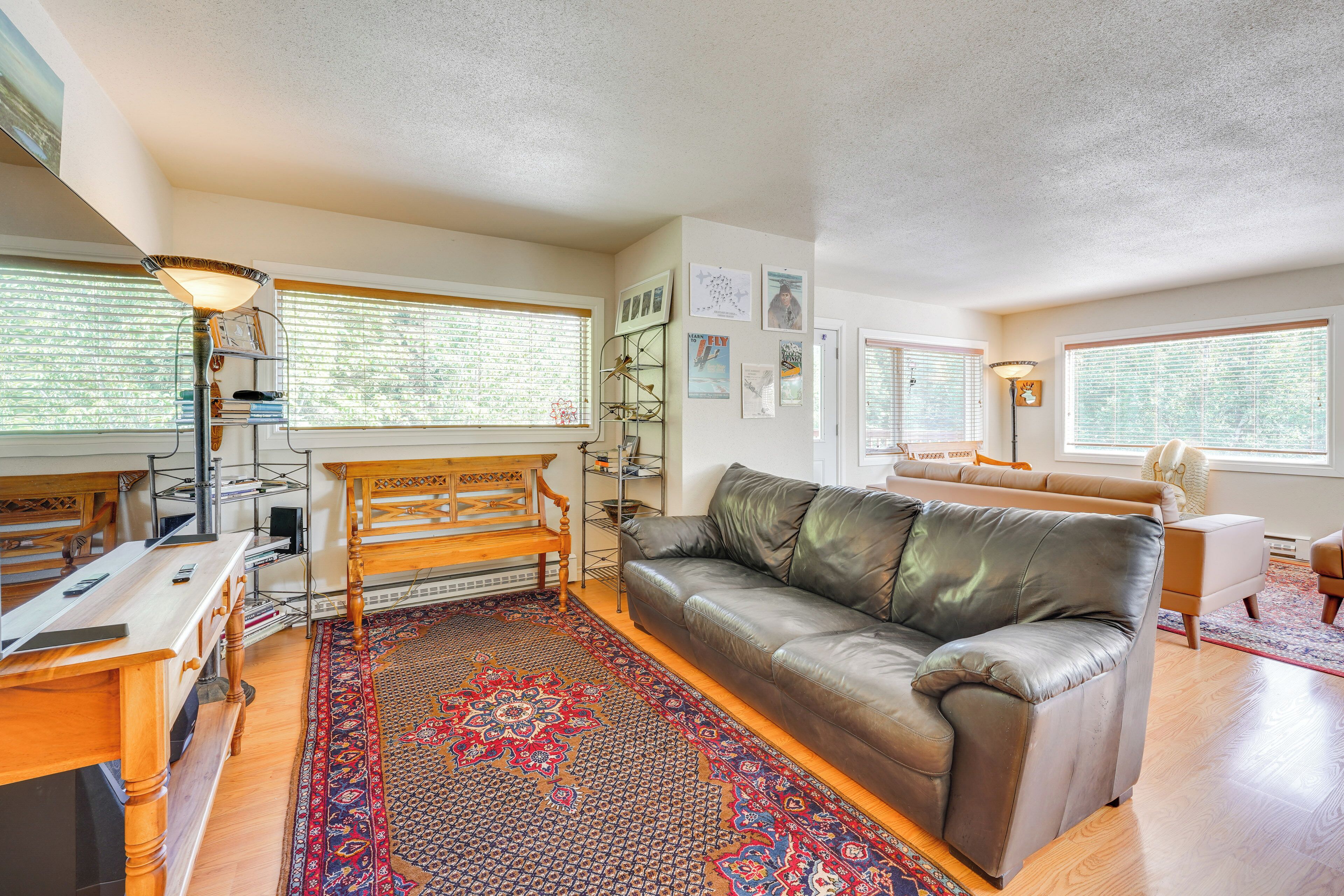 A living room with a leather sofa, wooden coffee table, and a patterned rug.