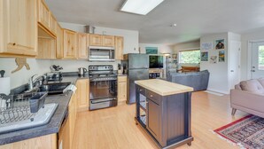 Una cucina moderna con mobili in legno, elettrodomestici in acciaio inossidabile e un'isola centrale.