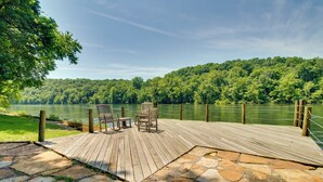 A wooden deck with stone flooring, overlooking a lake and forested hills. - White River Access & Views: Retreat w/ Shared Dock (Gassville)