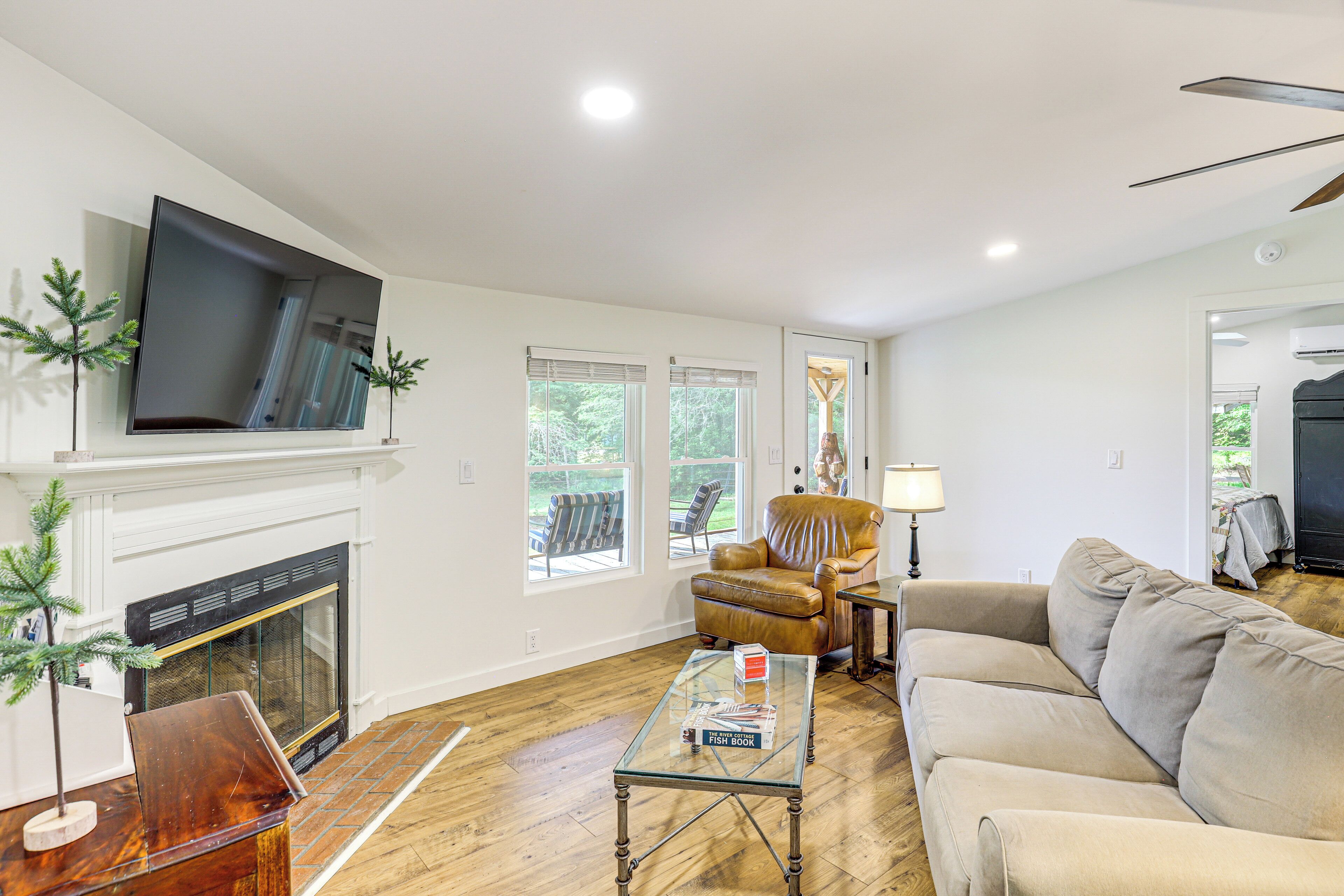 A living room with a fireplace, a sofa, a coffee table, and a TV mounted on the wall.