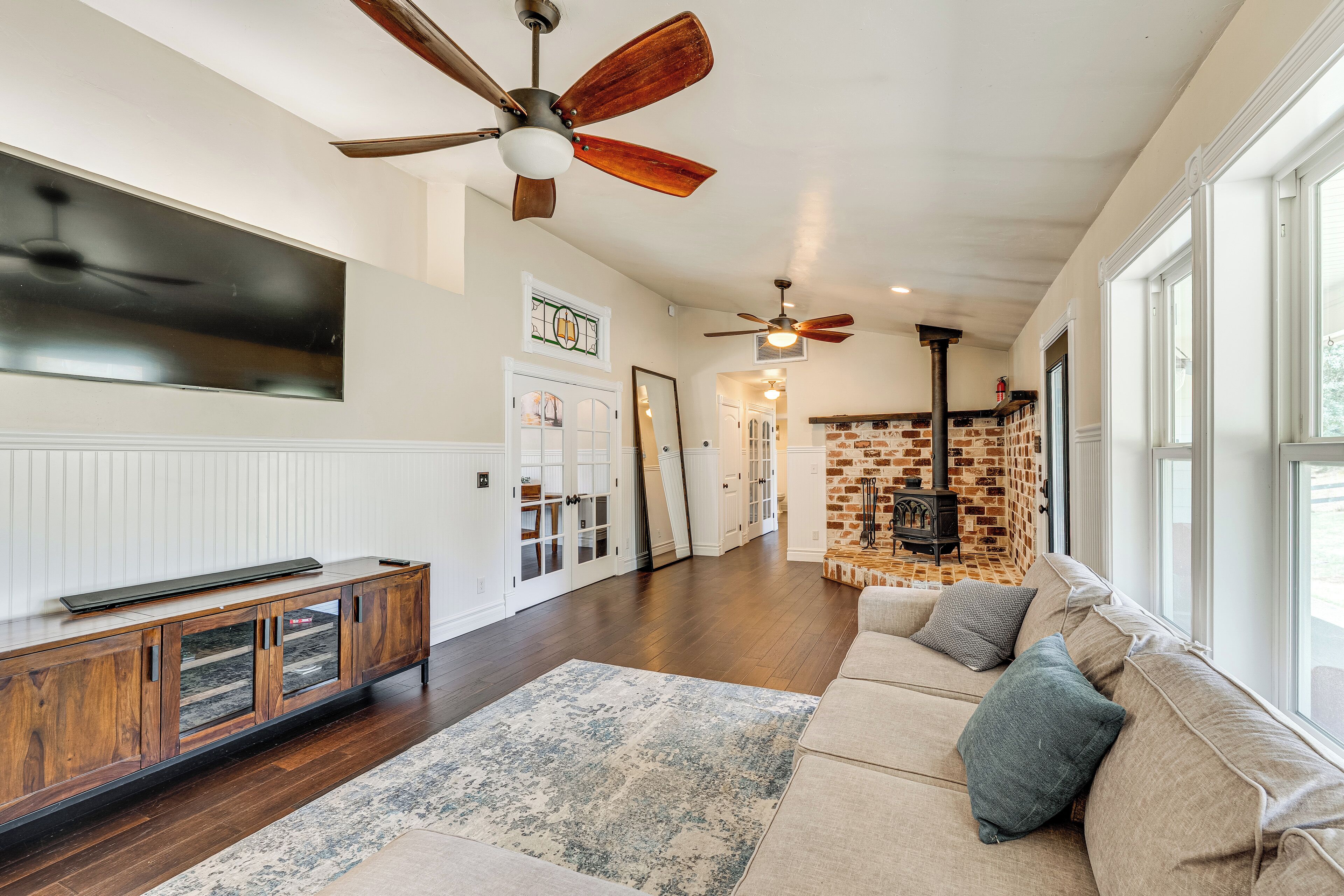 A spacious living room with a large sofa, wooden flooring, and a fireplace.