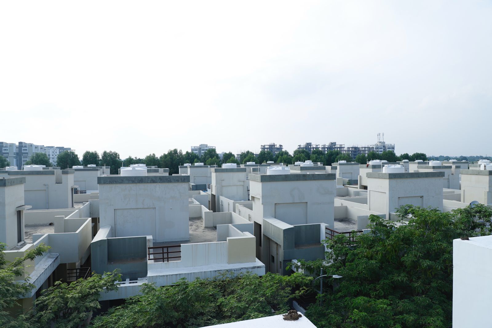 A rooftop view of a residential area with multiple buildings, some with flat roofs and others with small terraces.