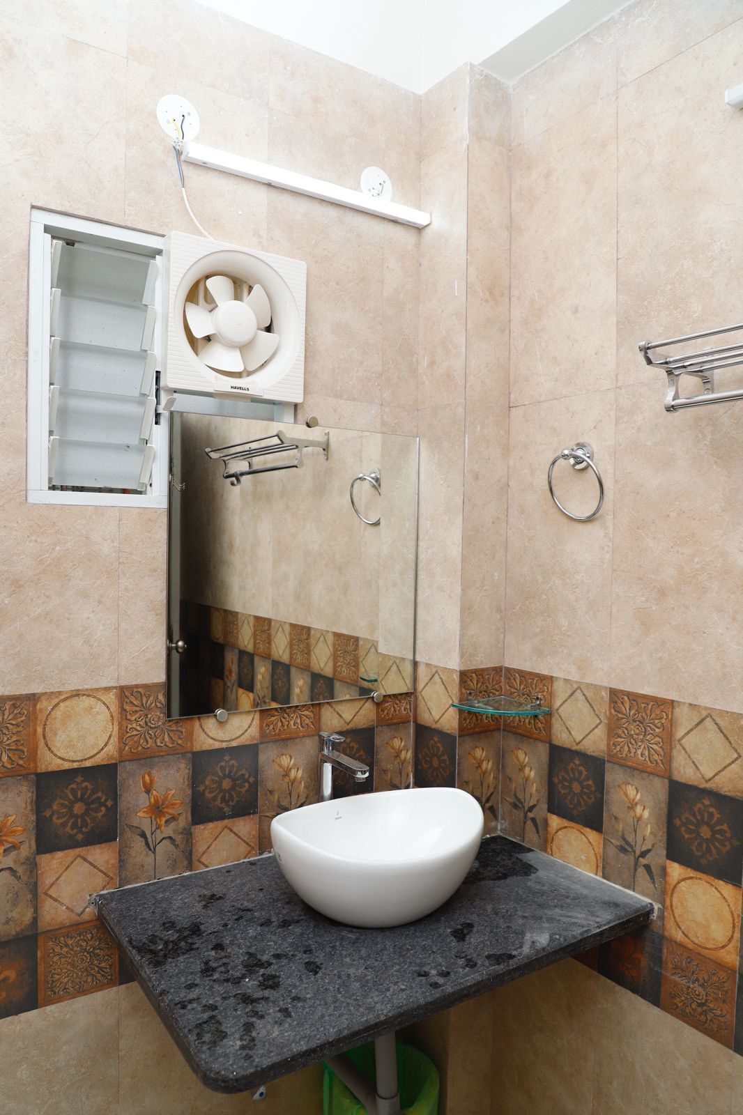 A bathroom with a white sink, a mirror, a towel rack, and a shower with a glass door.
