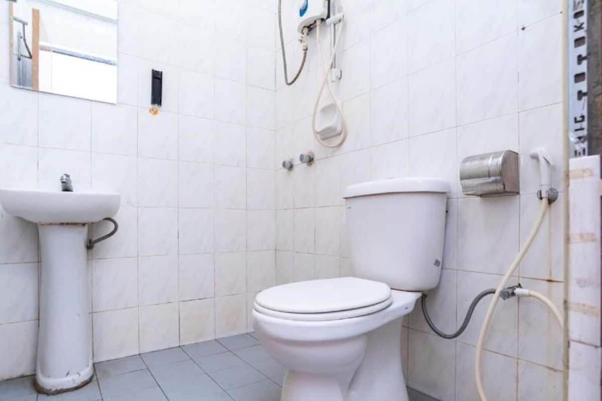 Ein kleines, sauberes Badezimmer mit weißem Waschbecken, WC und Dusche.