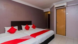 A hotel room with a large bed, a wooden door, and an air conditioning unit. - Golden Horse Hotel (Johor Bahru)