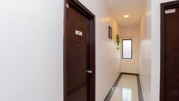 Un pasillo con dos puertas de madera, cada una con un número.