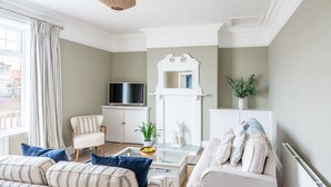 A living room with a sofa, armchair, coffee table, and a television. - The Look Out, Sheringham, Norfolk (Sheringham)