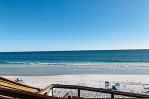 A beach with a wooden deck and two blue beach chairs. - Updated Destin Beach Walk Condo Quick Beach Access Sandpiper Cove Unit 9102 (Destin)