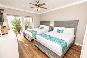 A double room with two beds, a ceiling fan, a window with curtains, and a wooden floor. - Updated Destin Beach Walk Condo Quick Beach Access Sandpiper Cove Unit 9102 (Destin)
