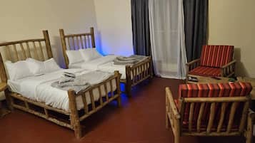 A rustic room with a wooden bed, a wooden chair, and a small table.