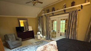 A bedroom with a bed, a ceiling fan, a dresser, a chair, and a window with curtains. - Spacious 6-bedroom home just steps from outdoor adventures! (Laconia)