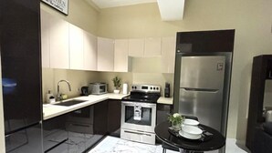 Eine moderne Küche mit Kühlschrank, Herd, Mikrowelle und Spüle.