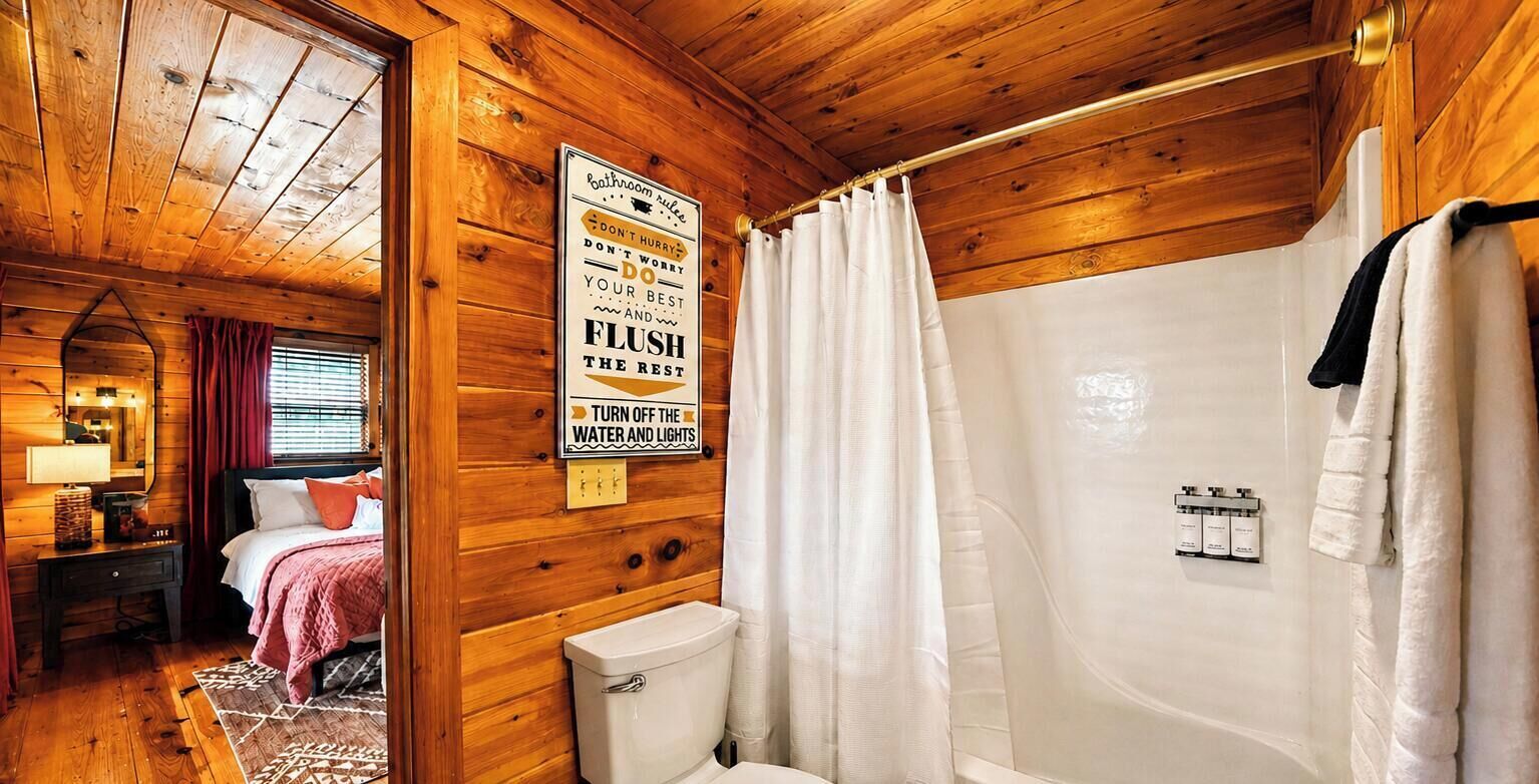 A wooden cabin bathroom with a shower, a toilet, and a sign with bathroom rules.