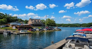 A lakeside property with a dock, boats, and a building with a sign. - Lakeside Luxury ♥ Sleeps 10 ♥ 3 Kings ♥ Hot Tub ♥ Arcade ♥ EV ♥ Lake Blue Ridge (Blue Ridge)